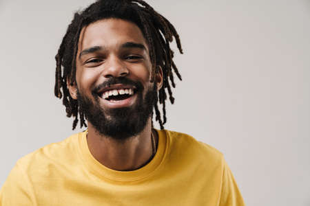 Image of a cheerful happy african guy posing isolated over grey wall background