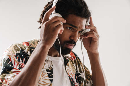 Close up portrait of a young black man listening to music with headphones