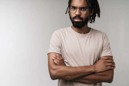 Image of serious african guy posing isolated over grey wall background in eyeglassesの写真素材