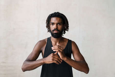 Image of young african american sportsman doing exercise while working out indoors