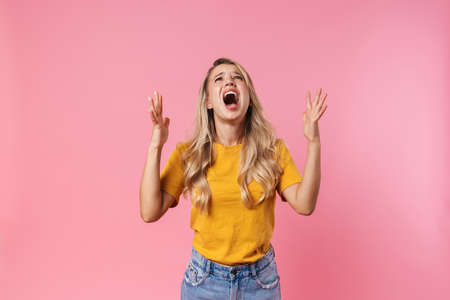 Photo of screaming stressed young woman isolated over pink wall background