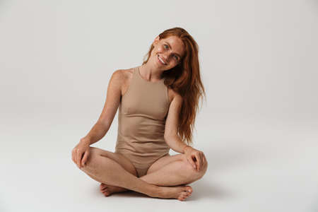 Photo of happy cheerful pretty redhead woman with freckles posing isolated over white wall...