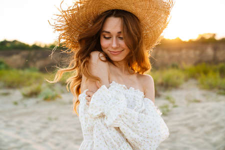 Young caucasian attractive brunette woman in straw hat smiling outdoorsの写真素材