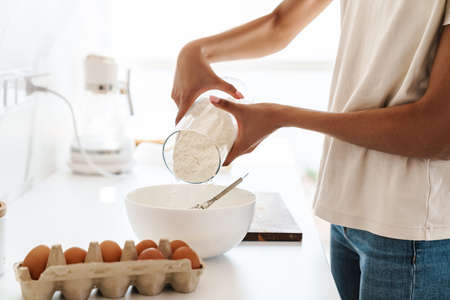 Cropped photo of a young african woman cooking at the kitchen at homeの写真素材