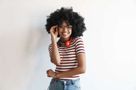 Happy african american student girl with headphones smiling at camera isolated over white background