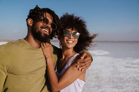 Image of happy african american couple laughing and hugging while posing in salt valleyの写真素材