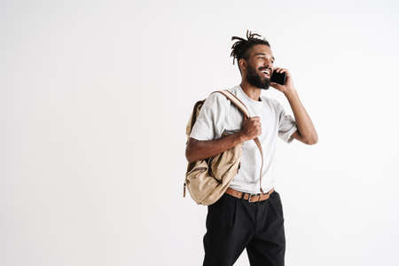 Photo of joyful african american guy talking on mobile phone isolated over white backgroundの写真素材