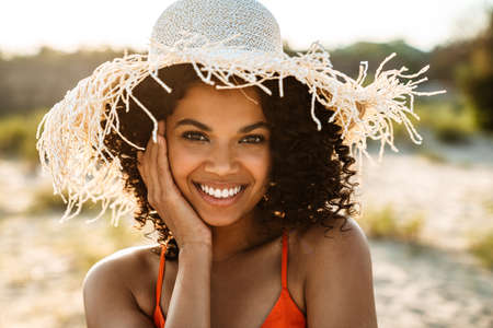 Image of happy positive young african woman posing at the beach outsideの写真素材