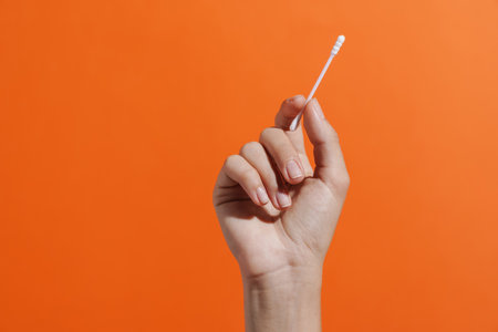 Close up of woman's hand holding a cotton swab isolatedの写真素材