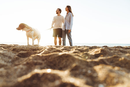 Image of a young family loving couple with dog outside at the beachの写真素材