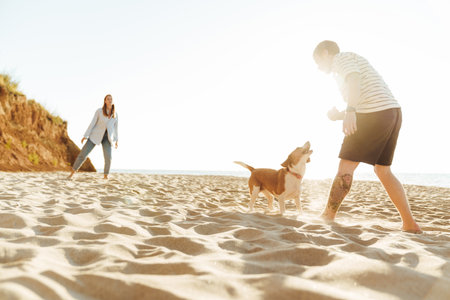 Photo of a young amazing loving couple with dog outside at the beachの写真素材