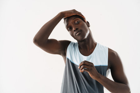 Young african american sportsman stretching his neck while working out isolated over white backgroundの写真素材