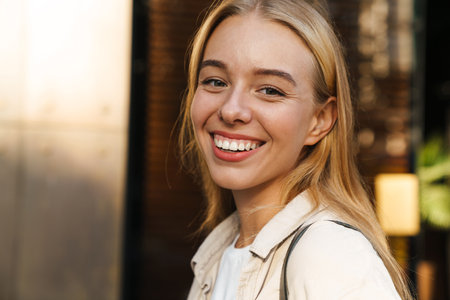 Close up of a smiling young woman walking outdoorsの写真素材