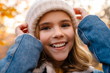 Image of young beautiful happy girl walking outdoors in autumn park