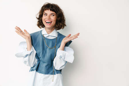 Excited beautiful girl posing and laughing at camera isolated over white background
