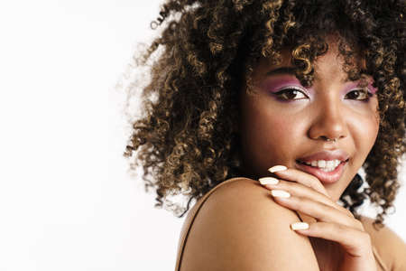 Pleased african american girl with piercing looking at camera isolated over white backgroundの写真素材