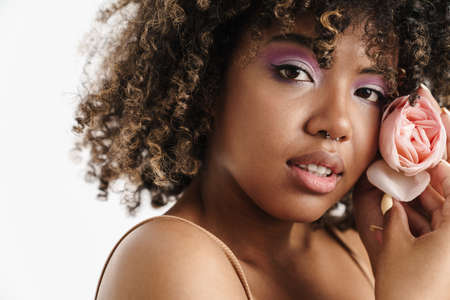 Beautiful nice african american girl posing with rose isolated over white backgroundの写真素材