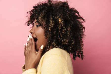 Excited african american woman expressing surprise on camera isolated over pink wall