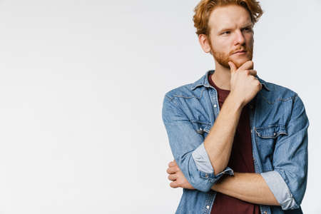 Brooding handsome ginger guy posing and looking aside isolated over white backgroundの写真素材