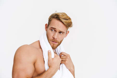 Confidence caucasian shirtless man posing with towel at camera isolated over white backgroundの写真素材