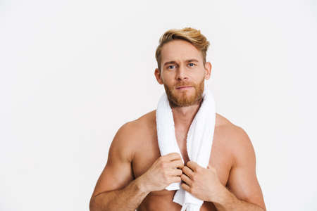Confidence caucasian shirtless man posing with towel at camera isolated over white backgroundの写真素材