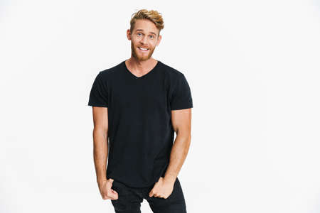 Pleased caucasian blonde man posing and smiling at camera isolated over white backgroundの写真素材