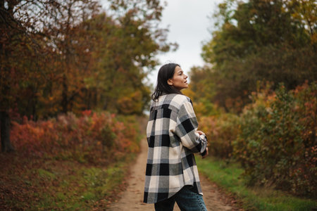 Beautiful brunette nice woman strolling in autumn forestの写真素材
