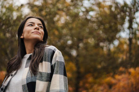 Beautiful brunette nice woman strolling in autumn forestの写真素材
