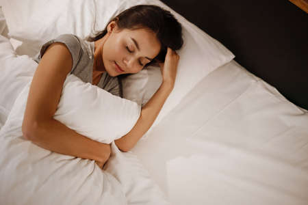 Brunette beautiful caucasian woman sleeping in bed at home