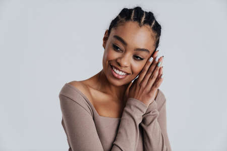 Beautiful african american woman smiling and looking aside isolated over white backgroundの写真素材
