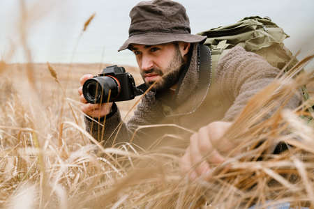 Focused photographer taking photo on digital camera outdoorsの写真素材