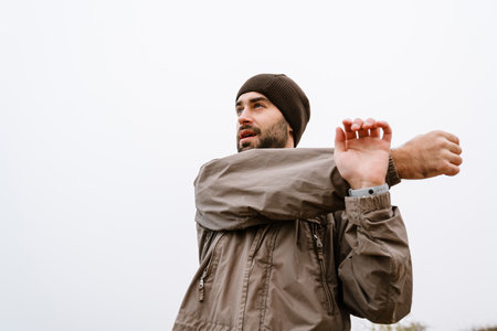Focused handsome man doing exercise while working out outdoorsの写真素材