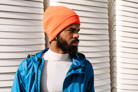 Serious african american sportsman in earphones posing and looking aside outdoorsの写真素材