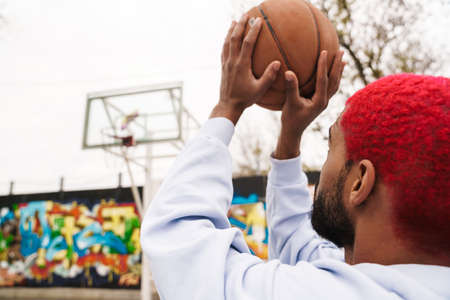Bearded african american guy playing basketball at playground outdoors