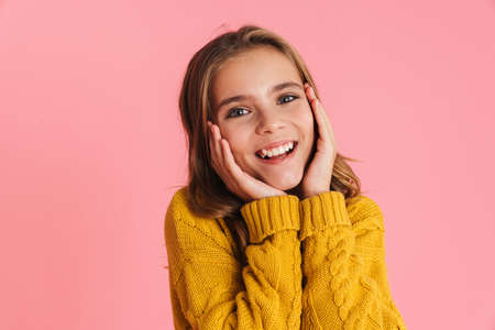 Happy beautiful blonde girl smiling and looking at camera isolated over pink backgroundの写真素材