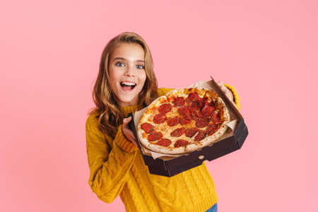 Happy beautiful blonde girl posing with pizza on camera isolated over pink backgroundの写真素材