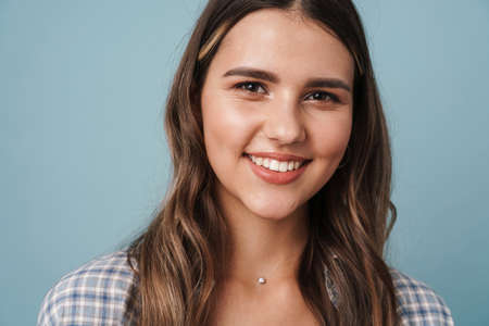 Lovely young girl wearing casual clothes posing isolated over blue background, close upの写真素材