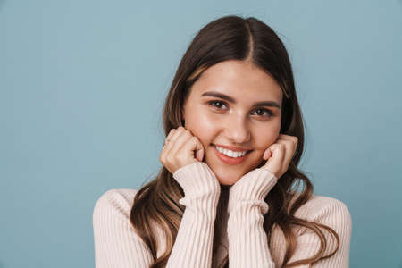 Lovely young girl wearing casual clothes posing isolated over blue background