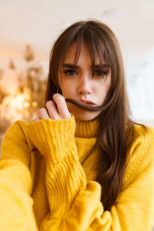 Charming upset nice girl taking selfie photo and looking at camera indoorsの写真素材