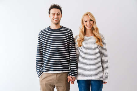 Happy young couple holding hands isolated over white backgroundの写真素材