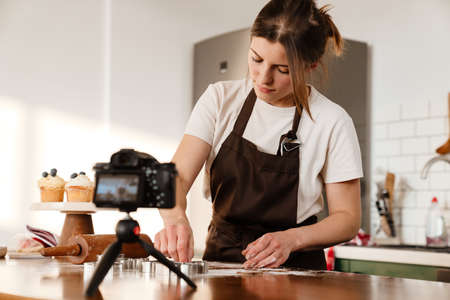 Camera footage of focused baker woman making Christmas cookies at home kitchenの写真素材