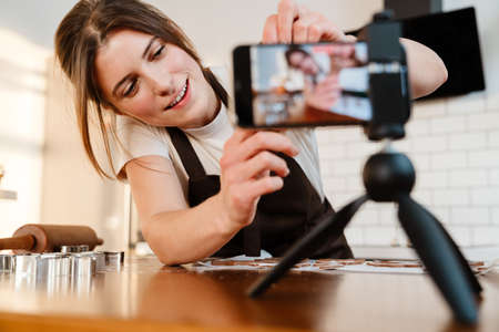 Camera footage of happy baker woman making Christmas cookie at home kitchen