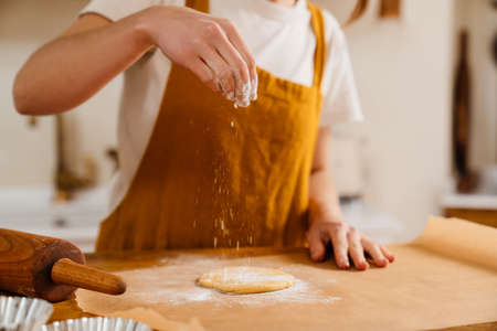 Caucasian pastry chef woman making cookies at cozy kitchenの写真素材