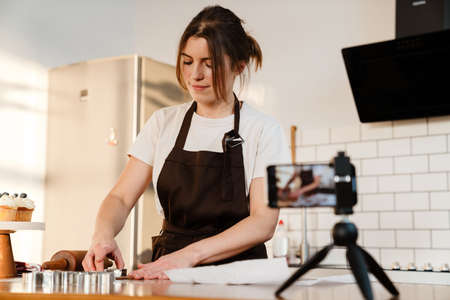 Camera footage of focused baker woman making cookies at home kitchenの写真素材