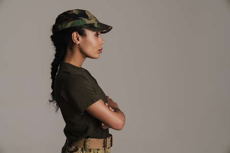 Confident african american soldier woman posing with arms crossed isolated over grey wallの写真素材