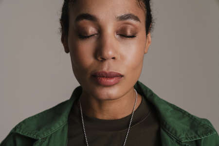 Calm african american soldier woman posing with eyes closed isolated over grey wall