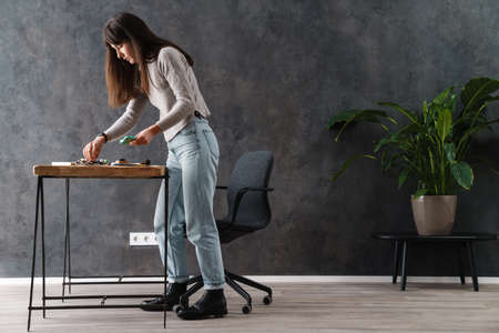 Serious beautiful calligrapher girl getting ready to work indoors