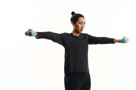 Focused african american woman working out with dumbbells isolated over white background