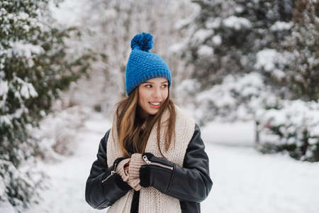 Happy attractive young woman in winter jacket enjoying weather outdoorsの写真素材