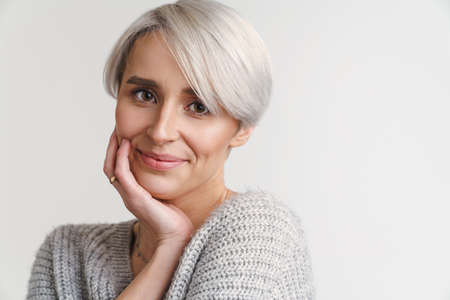 White-haired young woman smiling and looking at camera isolated over white wall